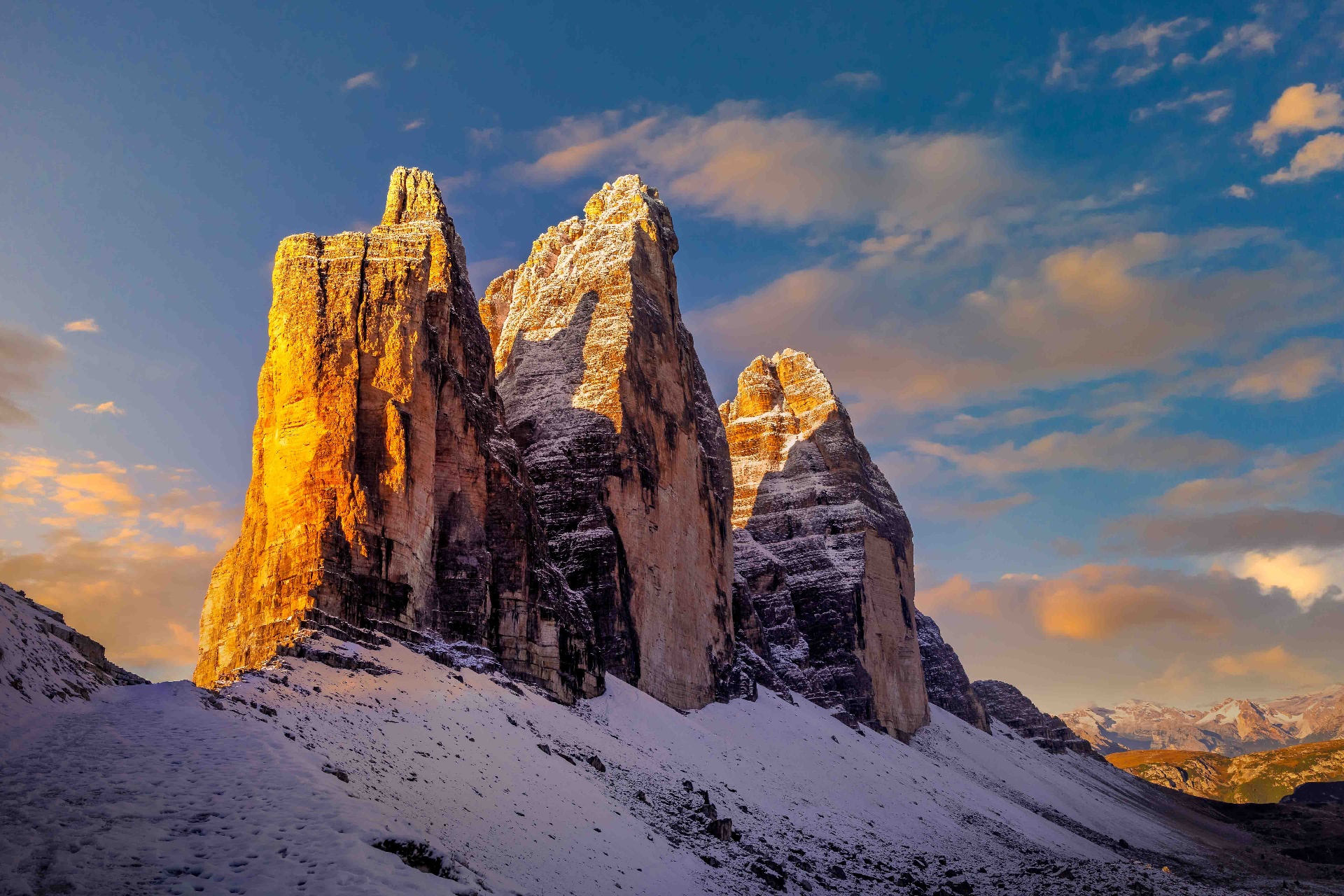 Tre Cime di Lavaredo lit by dawn against a deep-blue sky
