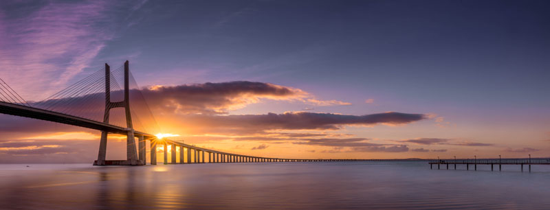 travel photography of the Morning Mist on the Tagus River under the Vasco Da Gama Bridge in Lisbon, Portugal